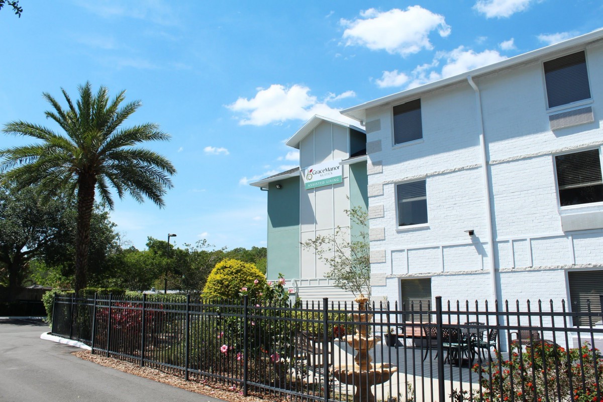 A sunny day view of an apartment building with surrounding palm trees and landscaping.