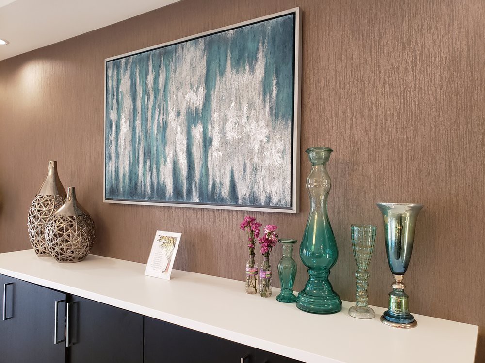 A stylish interior featuring abstract art and elegant vases on a sideboard.