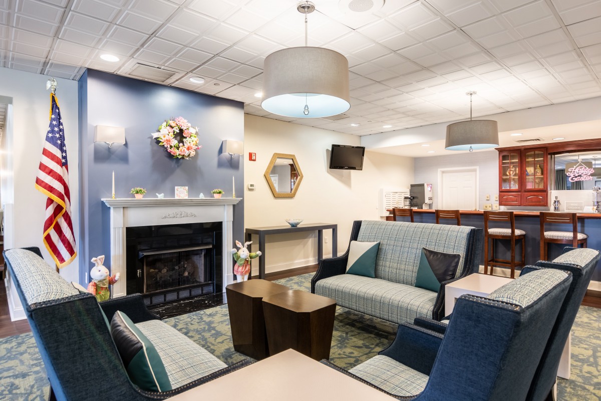 A cozy living room with modern furniture and a fireplace, featuring soothing lighting and decor.