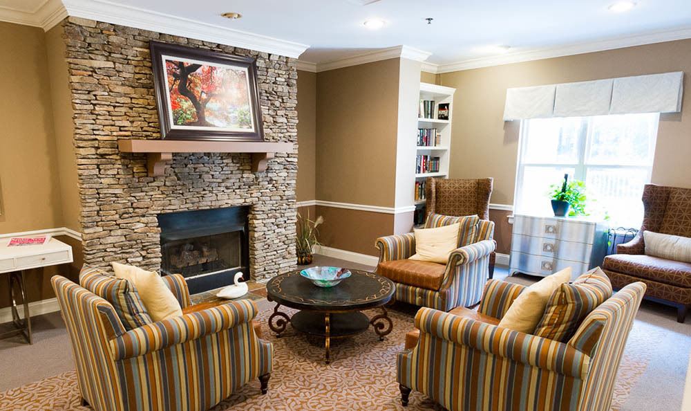 A cozy living room with a stone fireplace, armchairs, and a coffee table.