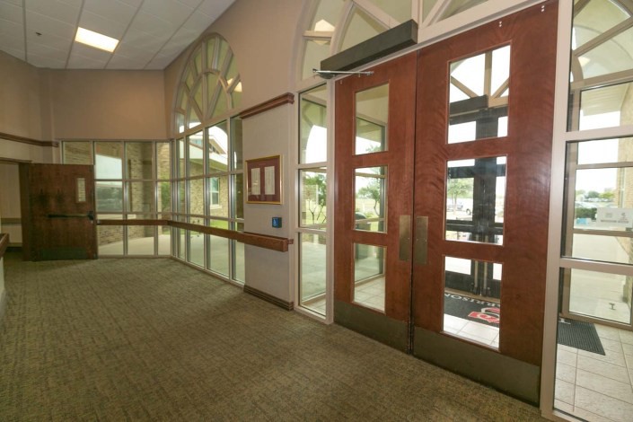 A spacious lobby entrance with glass doors and large windows.
