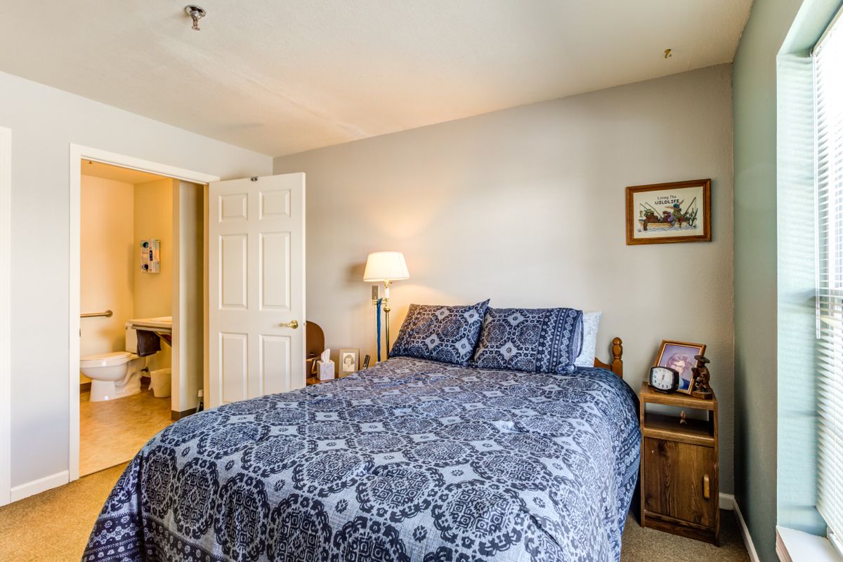 Cozy bedroom with patterned bedding and warm lighting.