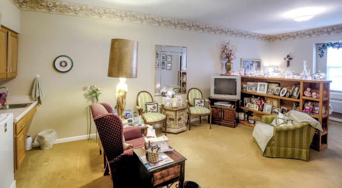 A cozy vintage-style living room with a TV, comfortable seating, and decorative elements.