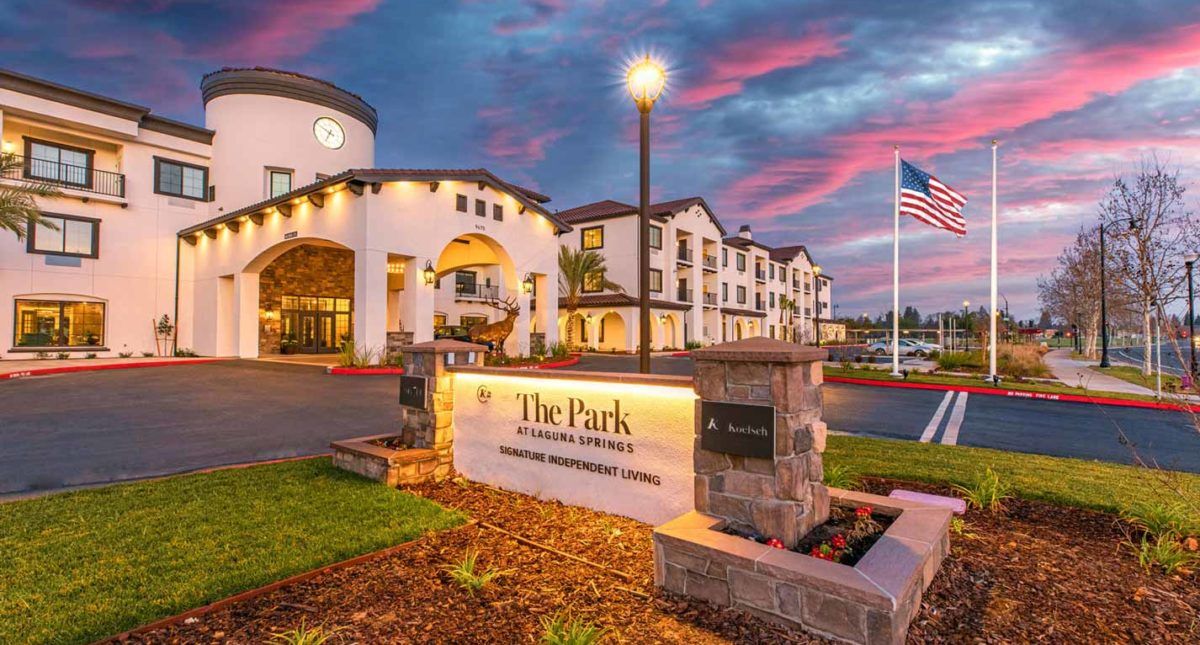The exterior of a hotel building during sunset, with clear signage and surrounding landscape.