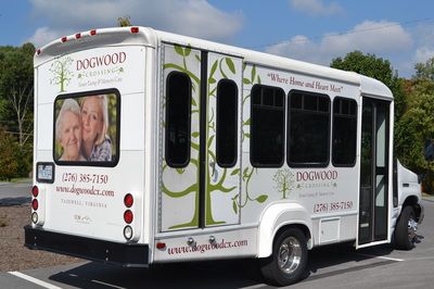 A shuttle bus with a tree-themed advertisement on its side.