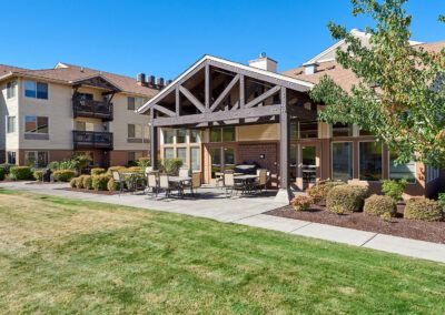 A modern apartment complex with a well-maintained outdoor patio and lawn area.