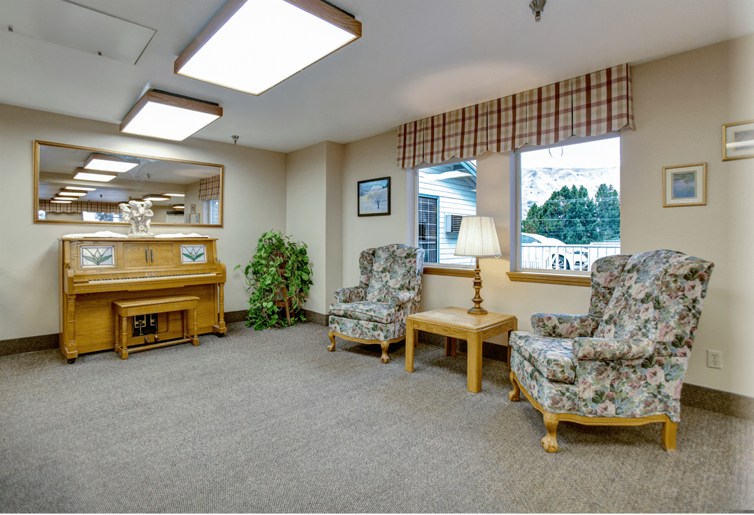 A cozy waiting area with a piano and seating arrangements.