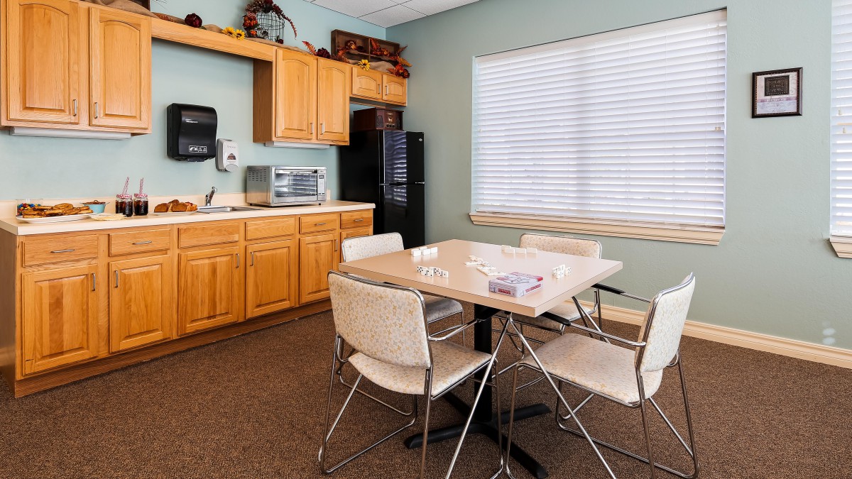 A cozy kitchen and dining area featuring a table with chairs, wooden cabinets, and various appliances.