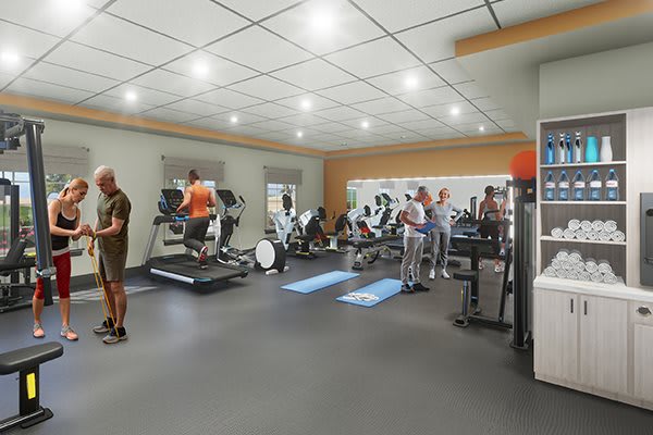 A busy gym with people using various exercise equipment.