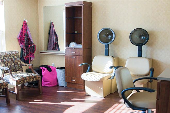 A cozy salon interior with hair dryers and seating, ready for clients.