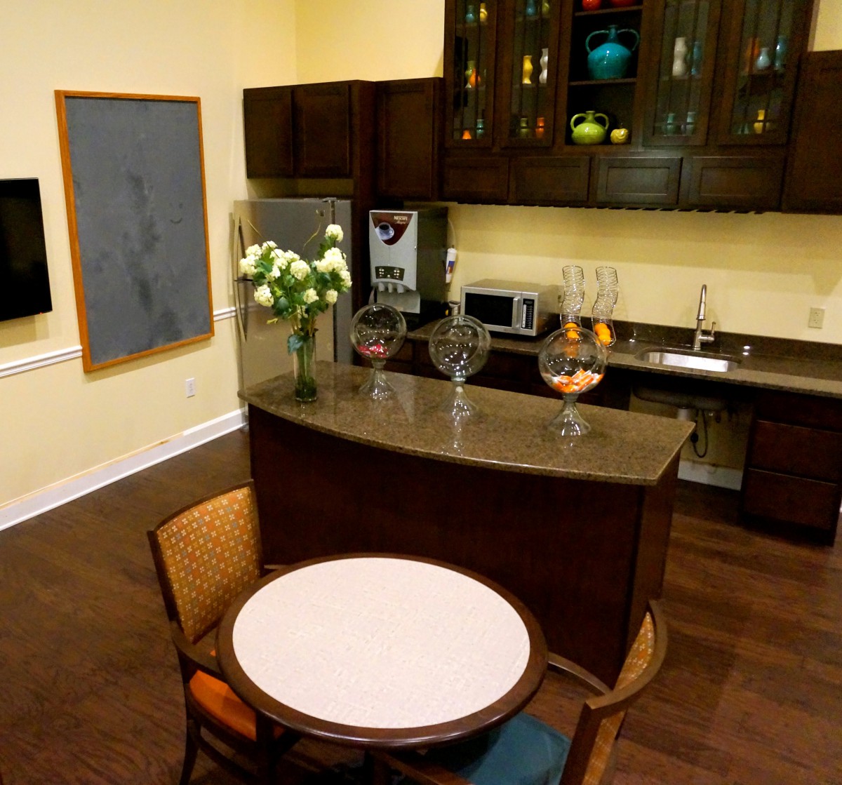 A modern kitchen with a small bar area, featuring a countertop and seating.