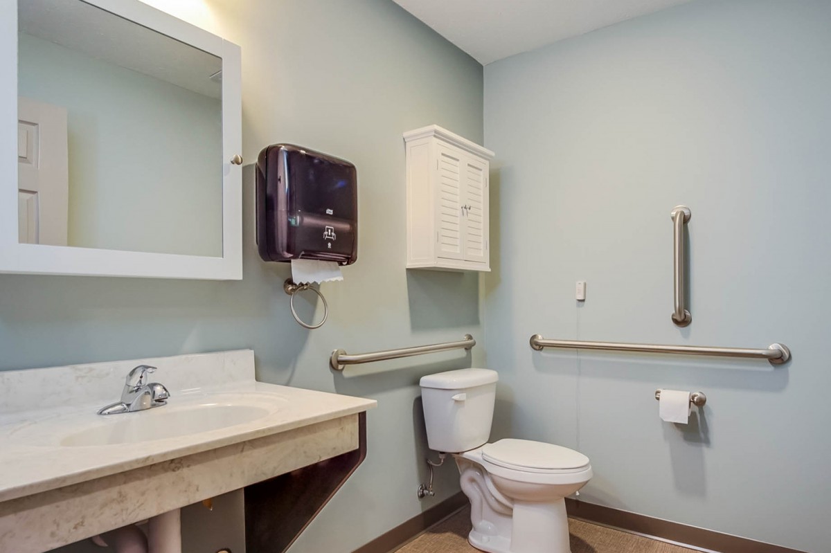 A clean, accessible bathroom with essential facilities and safety features.