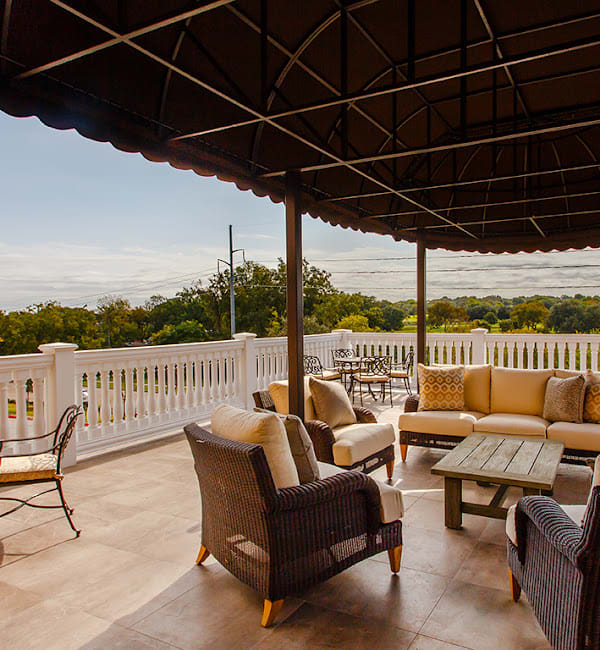 A cozy outdoor patio with comfortable seating and a scenic view.
