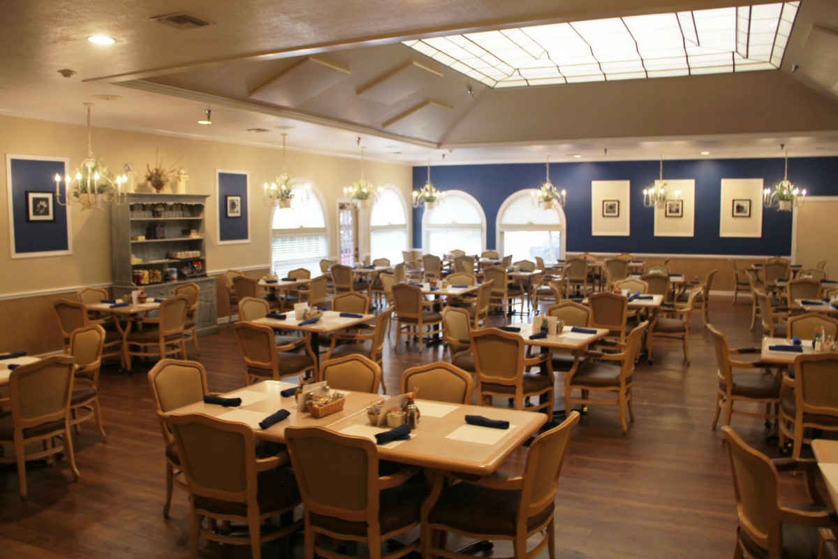 A well-lit restaurant dining area with neatly arranged tables and chairs.