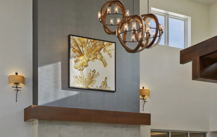 A modern living room featuring a stylish chandelier and abstract wall art.