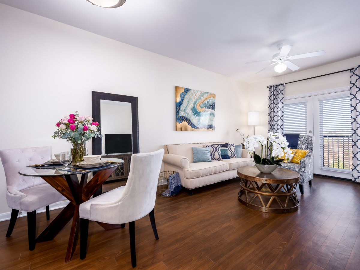 A stylish open-plan living room and dining area featuring modern decor and wooden flooring.