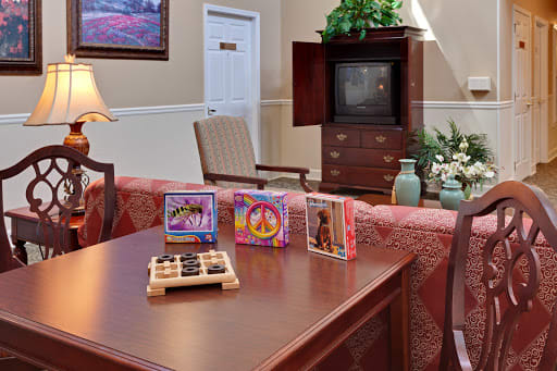 A cozy living room showcasing a vintage TV, CDs on a table, and comfortable seating.