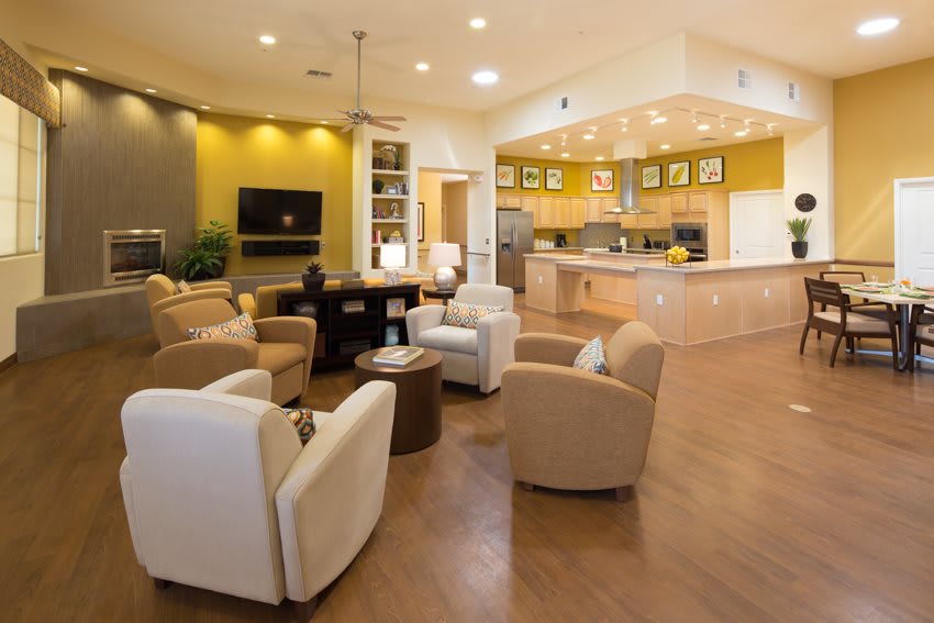 A modern living room with an open kitchen layout, featuring comfortable seating and stylish decor.