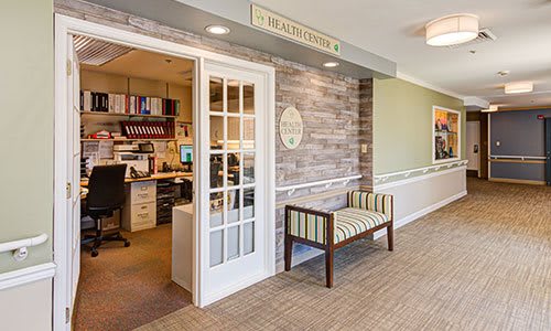 A welcoming office reception area with a desk and waiting bench.