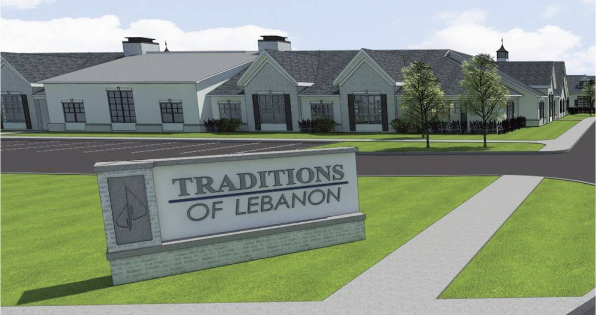 A sign reading 'Traditions of Lebanon' in front of a building with a well-maintained lawn.
