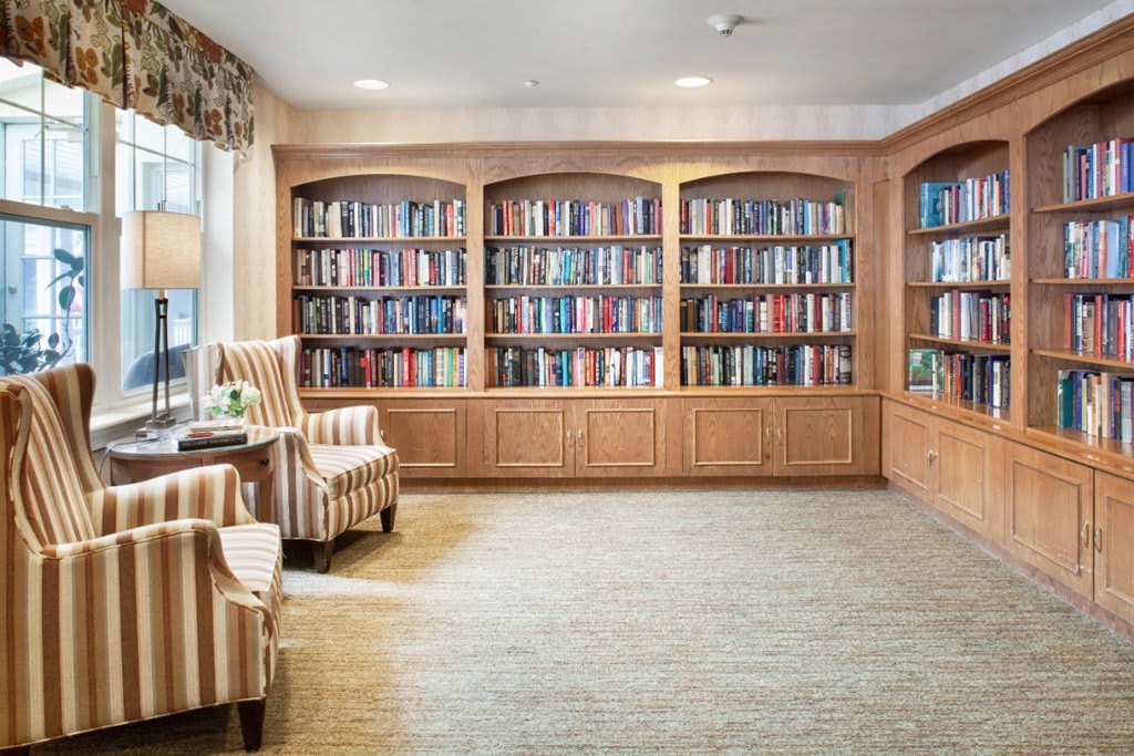 A cozy library corner with bookshelves and comfortable armchairs for reading.