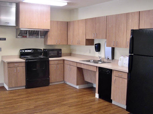 A modern kitchen featuring black appliances and wooden cabinets.