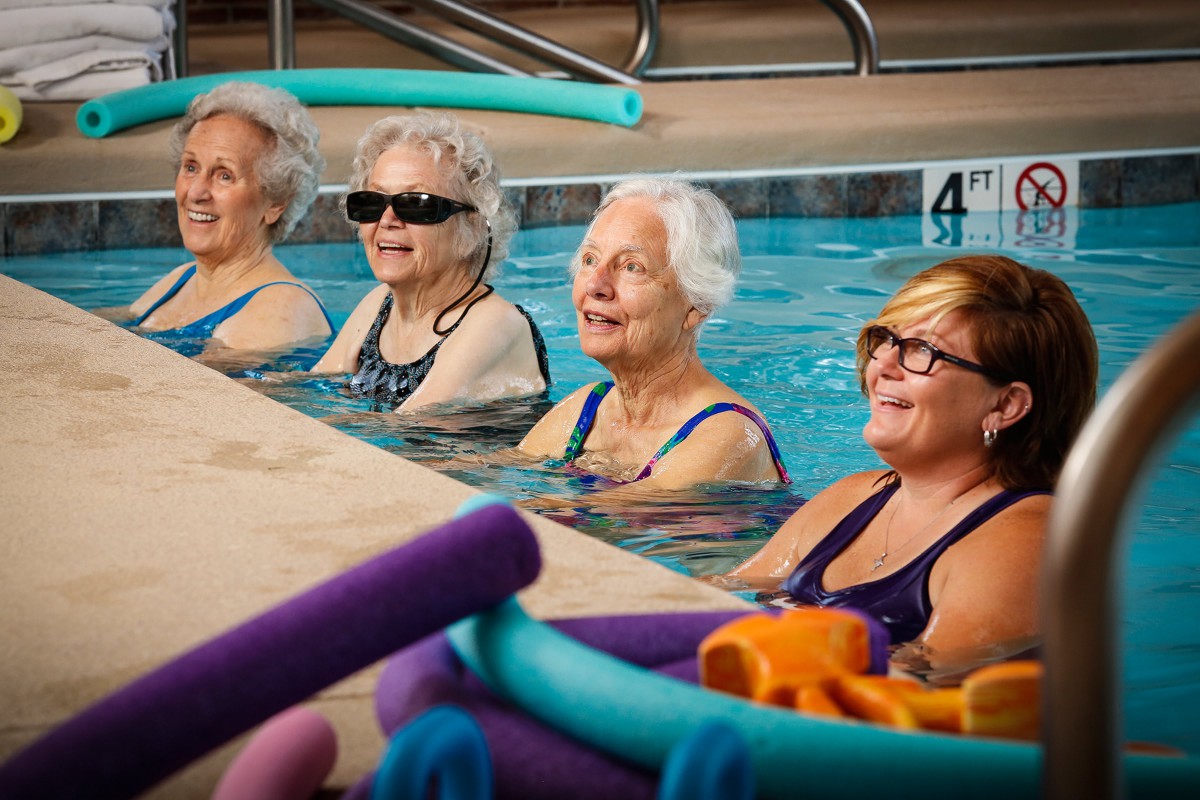 A group of elderly women enjoying a water aerobics class in a swimming pool.