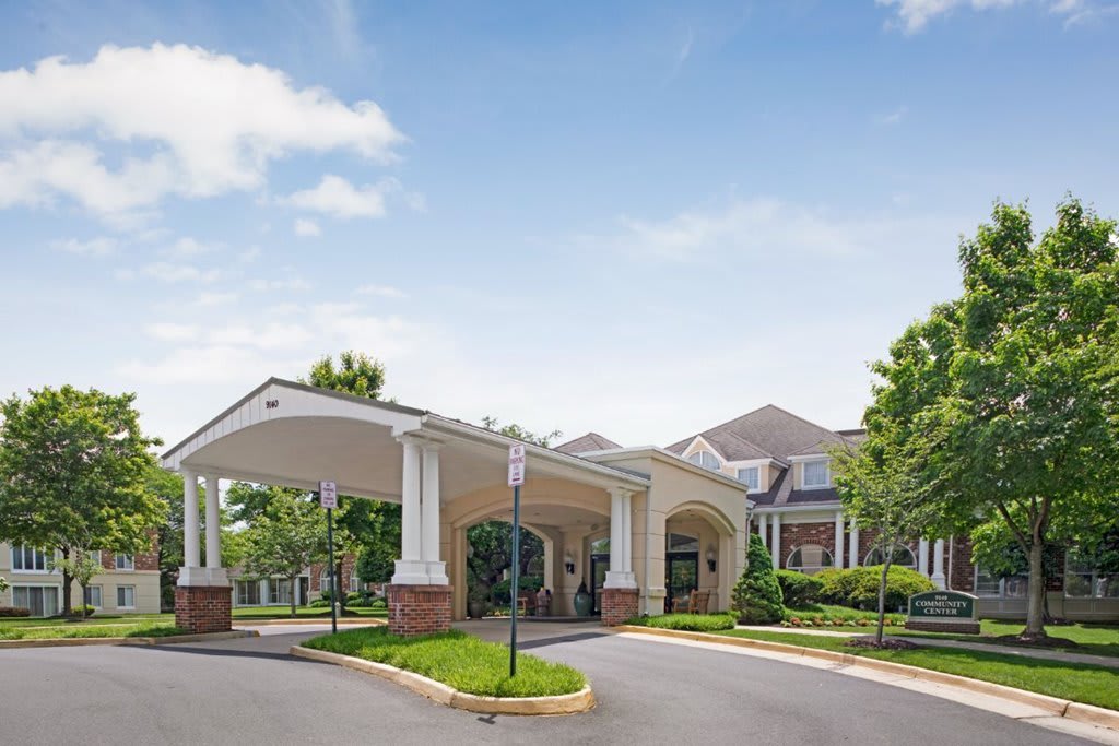 A building with a covered entrance and surrounding landscaping.