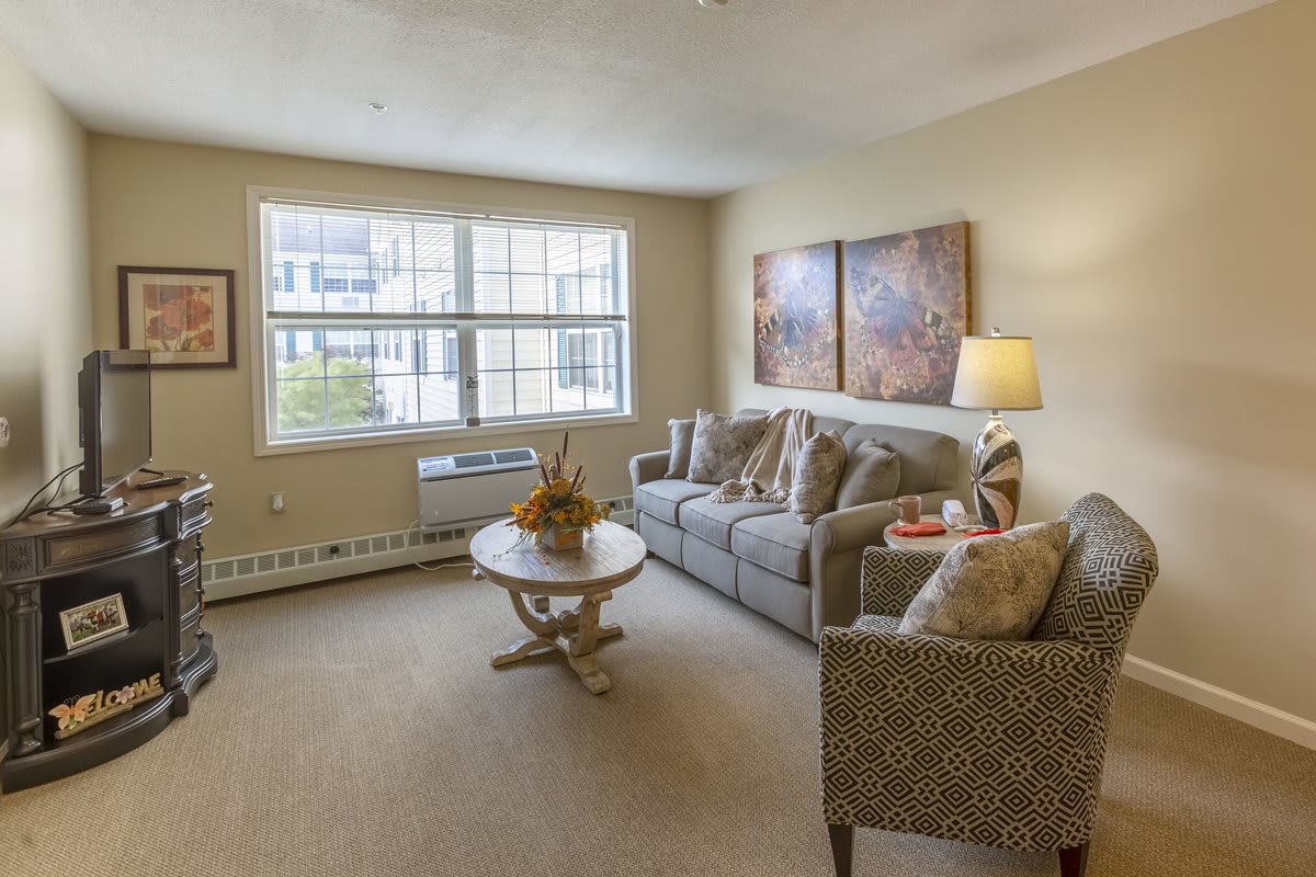 A cozy living room with a comfortable sofa, coffee table, and large window.