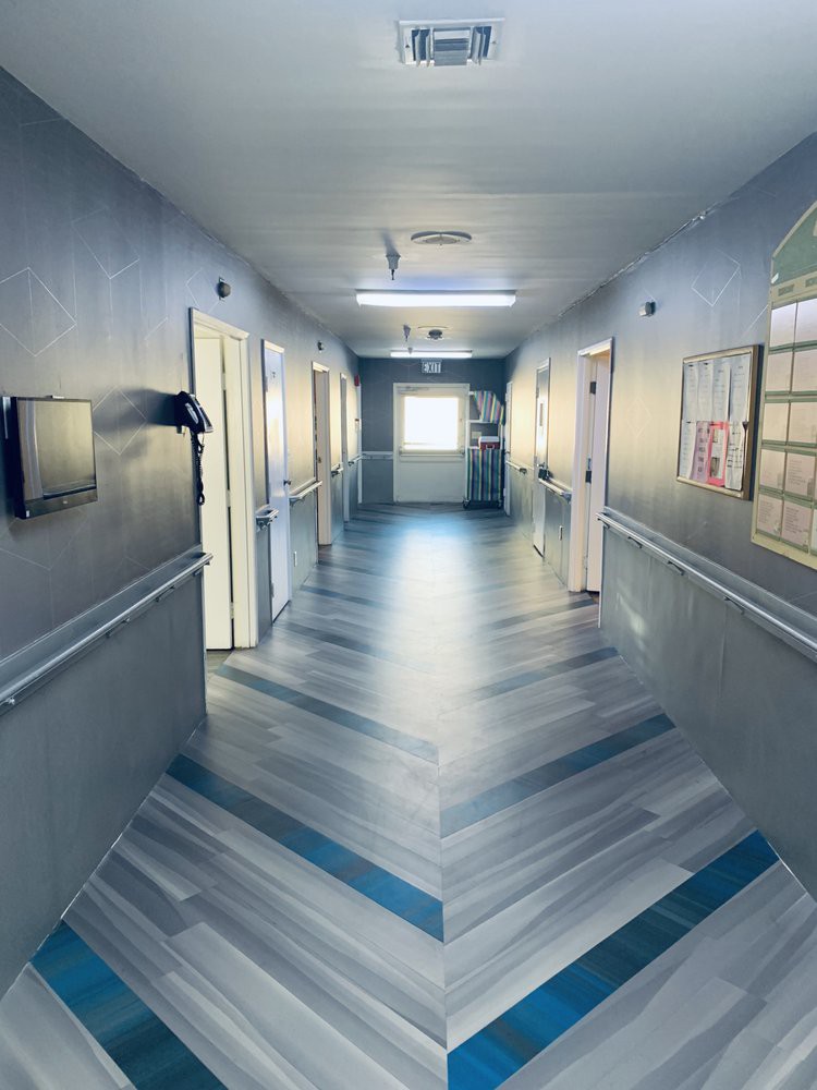 A clean and well-lit hospital corridor with doors on either side.