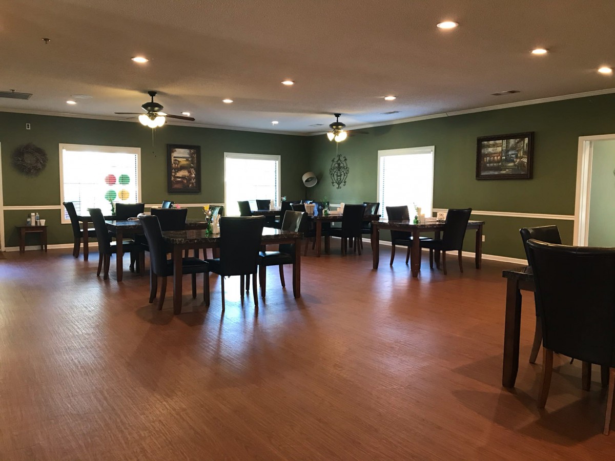An empty dining area with neatly arranged tables and chairs on a wooden floor.