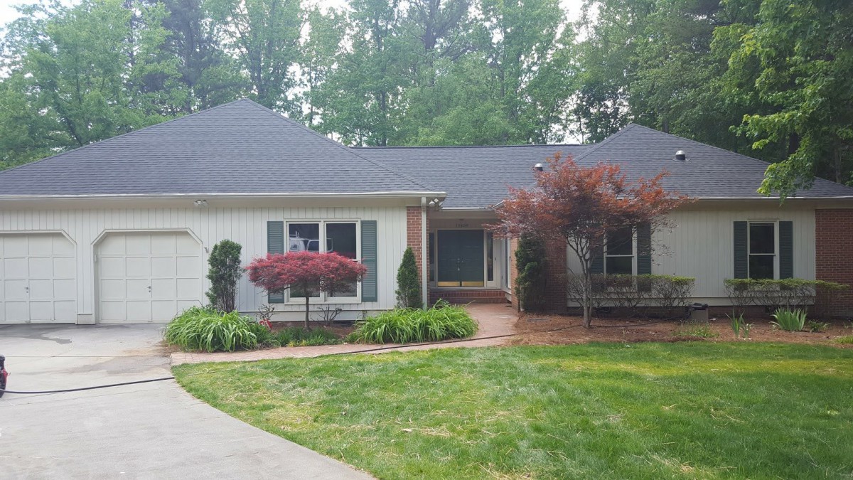 A charming suburban house surrounded by well-maintained landscaping and trees.