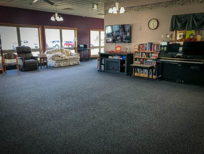 A spacious living room with a television, bookshelves, and comfortable seating.
