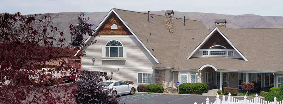 A suburban house with a car parked in the driveway.