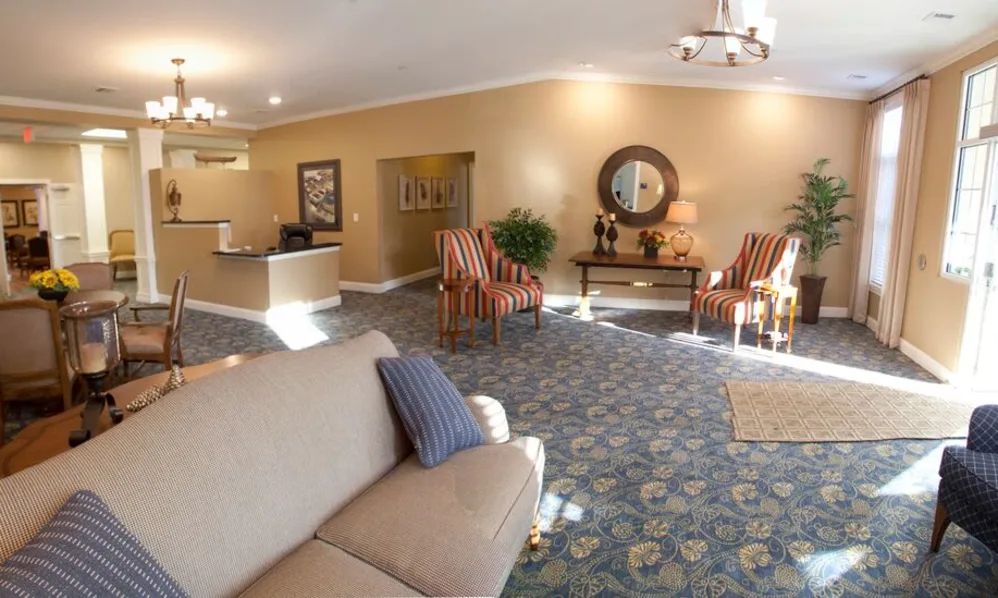 A spacious and elegantly decorated lobby with seating, plants, and a reception desk.