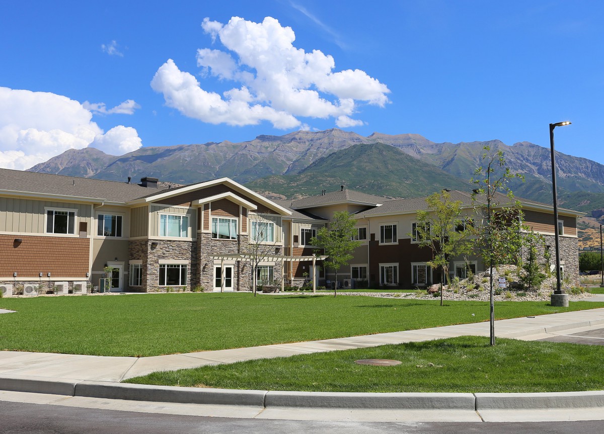 A scenic view of a building with mountains and a blue sky in the background.