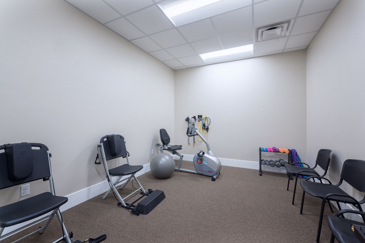 A small fitness room with exercise equipment including a stationary bike and exercise ball.