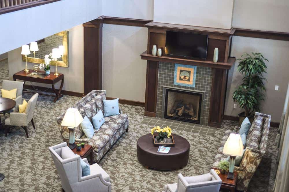 A cozy and well-decorated living room with sofas, chairs, a fireplace, and a coffee table.