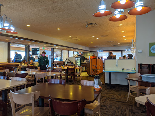 A cozy dining area in a restaurant, featuring tables and staff attending to customers.