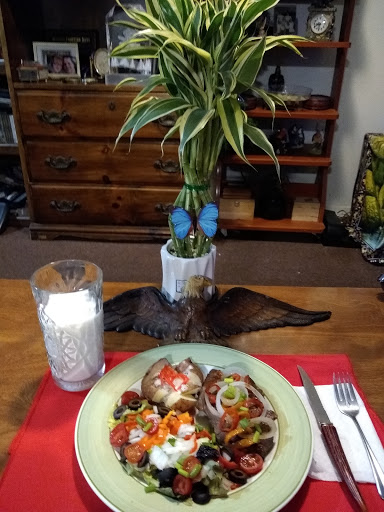 A beautifully arranged meal on a dining table featuring colorful vegetables and a refreshing glass of water.