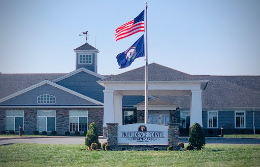 The entrance of a building featuring the United States and Virginia flags.