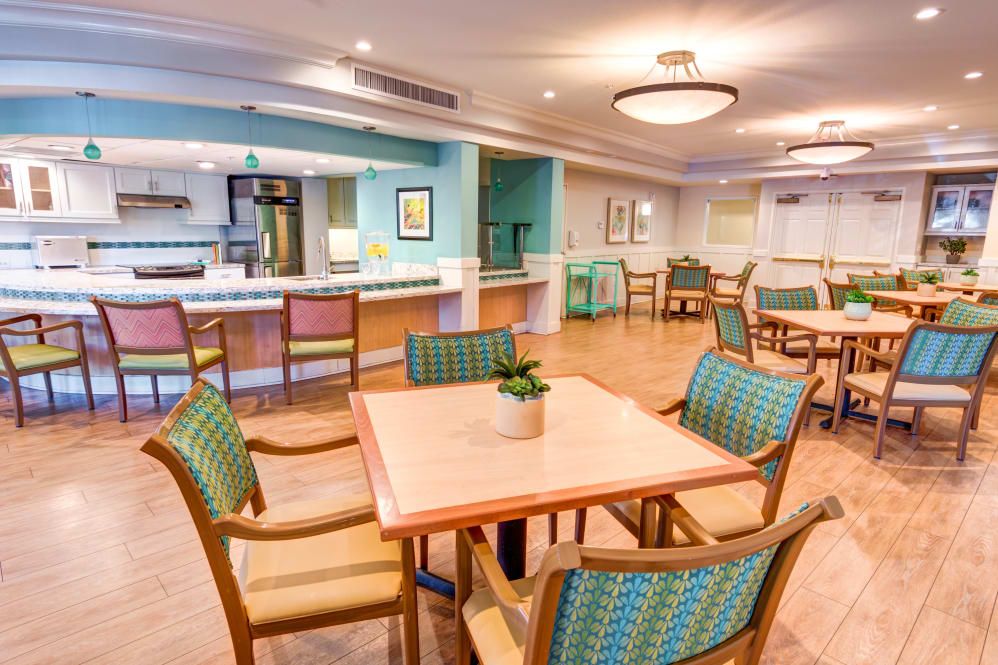 A bright and modern dining area with wooden floors, neatly arranged tables and chairs.