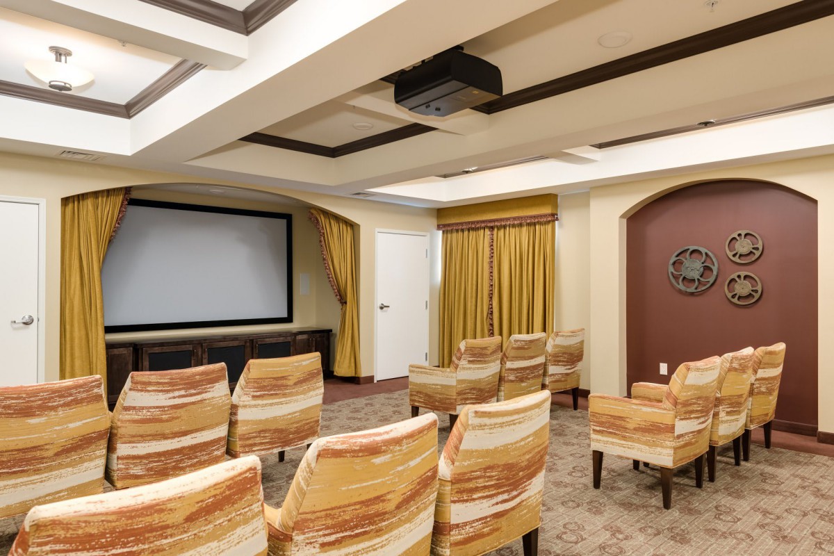 A well-arranged conference room with a projector screen and rows of chairs.