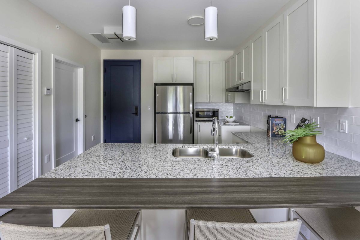A modern kitchen with granite countertops and stainless steel appliances.