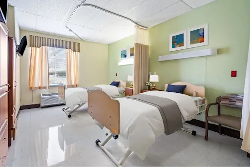 A bright and welcoming hospital patient room featuring two beds and modern decor.