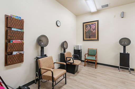 A serene waiting area in a salon, featuring comfortable chairs and hair dryers.