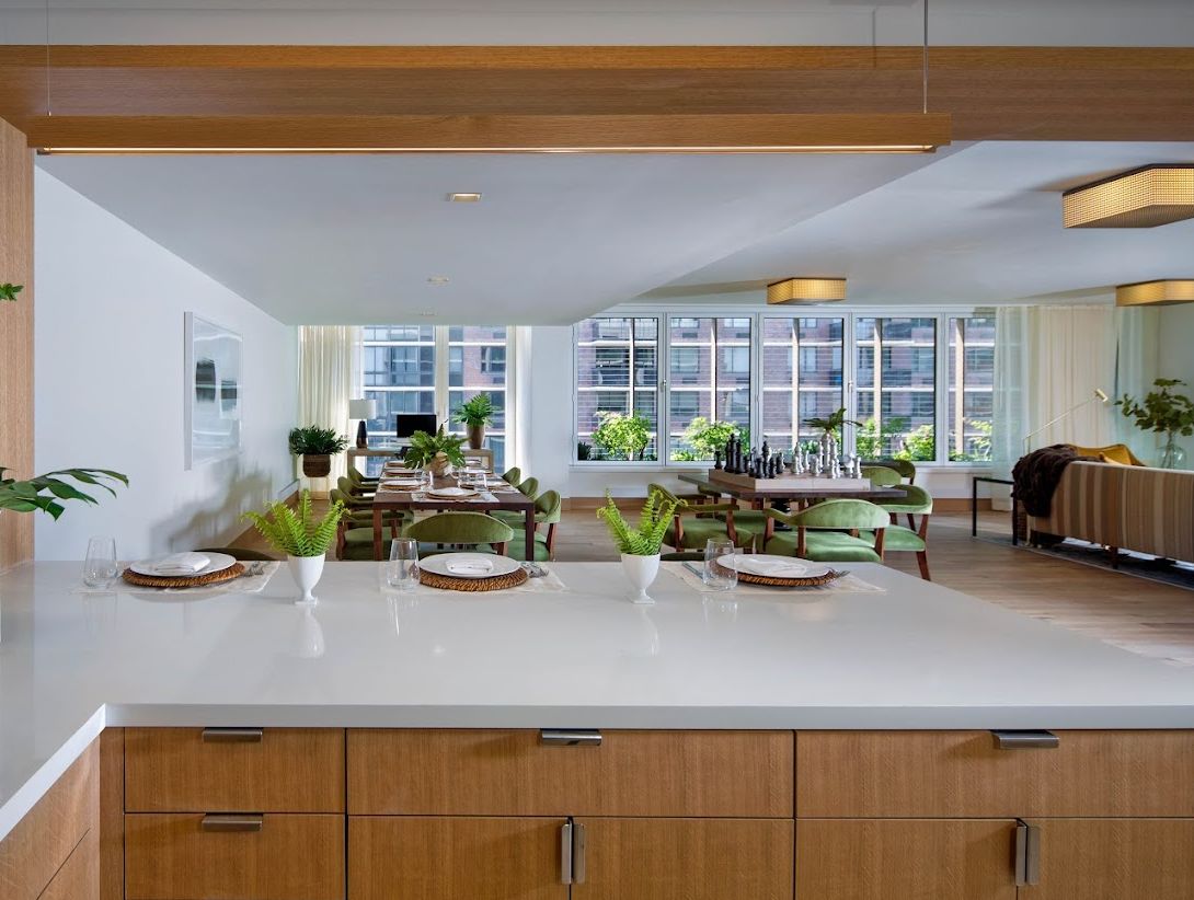 A modern open-concept kitchen and dining area with ample natural light and greenery.