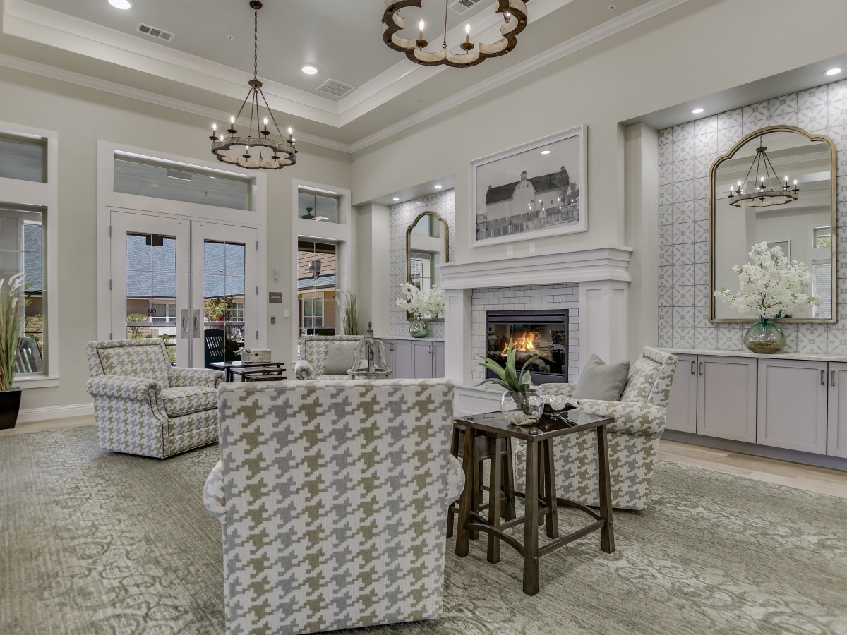 A stylish and cozy living room with elegant chandeliers, a modern fireplace, and comfortable seating.