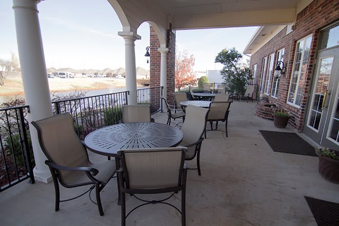 An outdoor patio with tables and chairs overlooking a scenic view.