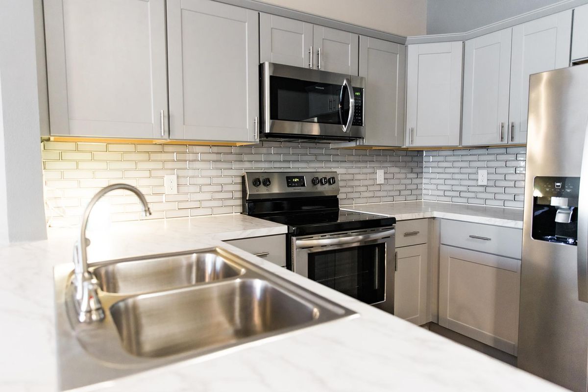 A modern kitchen with stainless steel appliances and white cabinets.